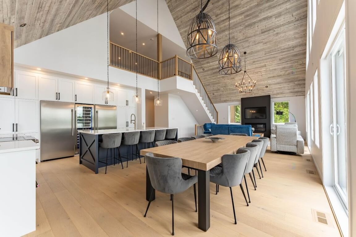 maison-style-chic-chalet-aire-ouverte-cuisine-salle-a-manger-morin-heights Vue intérieure à aire ouverte d'une maison de style chalet chic avec plafond cathédrale, plan personnalisé réalisé par Architecture MBTP