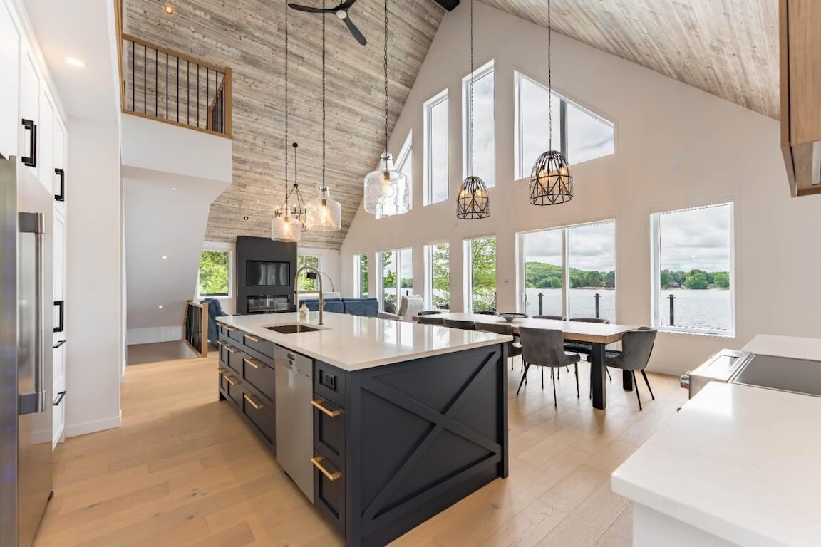 maison-style-chic-chalet-aire ouverte-plafond-cathédrale-morin-heights Vue intérieure à aire ouverte d'une maison de style chalet chic avec plafond cathédrale et vue panoramique sur le lac, plan personnalisé réalisé par Architecture MBTP