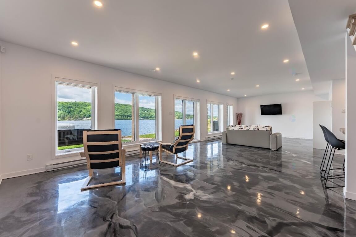 maison-style-chic-chalet-aire-ouverte-salon-vue-sur-le-lac-morin-heights Vue intérieure à aire ouverte d'une maison de style chalet chic avec vue sur le lac, plan personnalisé réalisé par Architecture MBTP